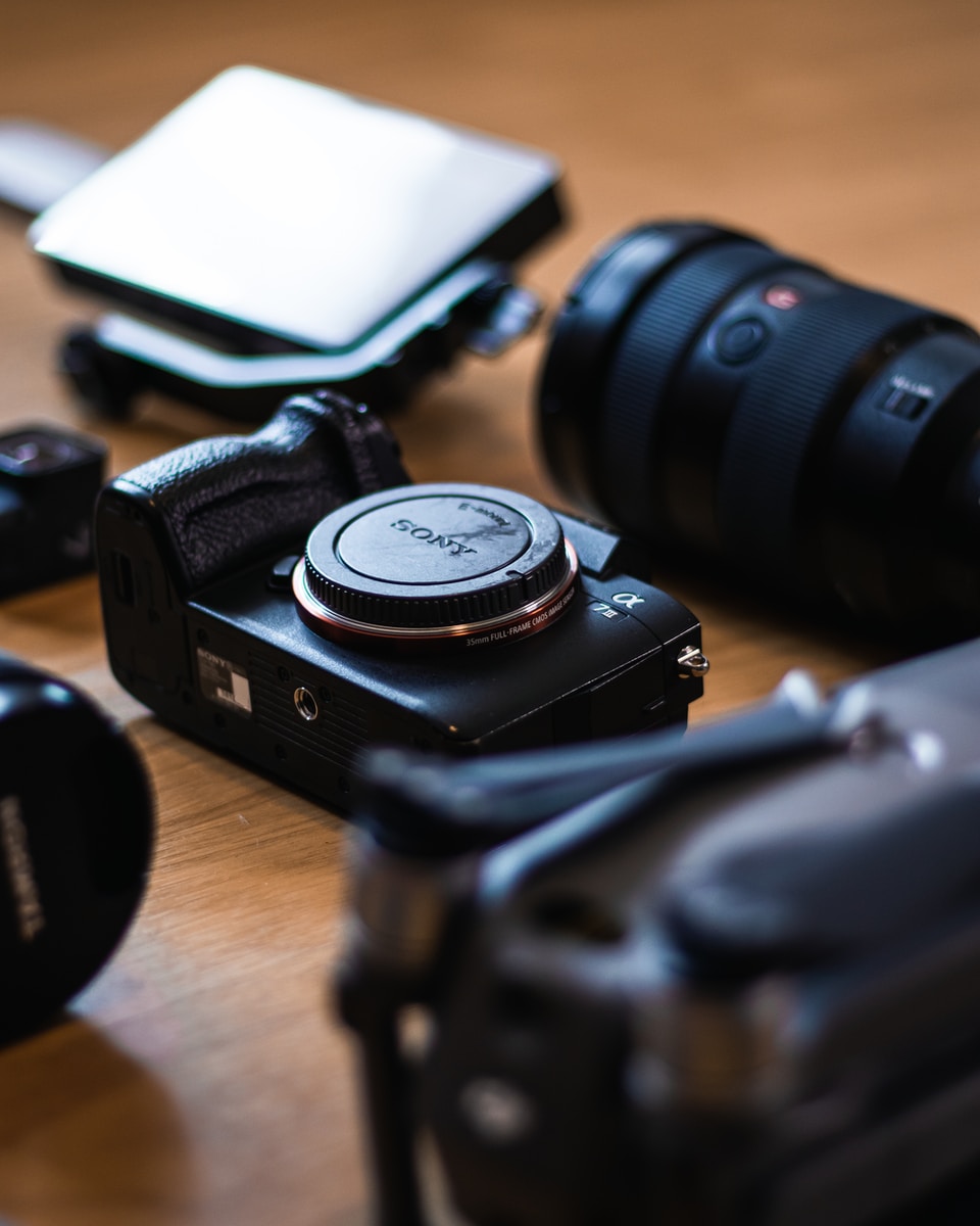 appareil photo reflex numérique noir sur une table en bois marron